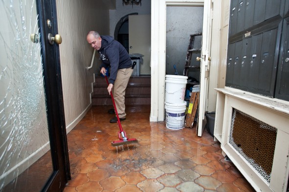 Homeowner Sweeps Out Water From Hurricane Sandy